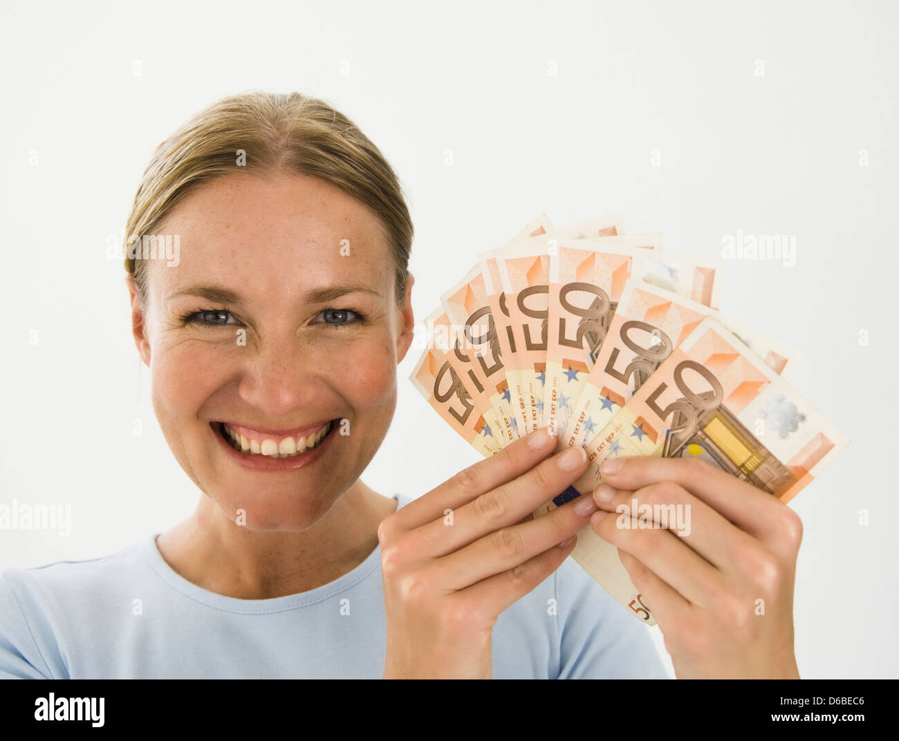 Lächelnde Frau hält Euro-Banknoten Stockfoto