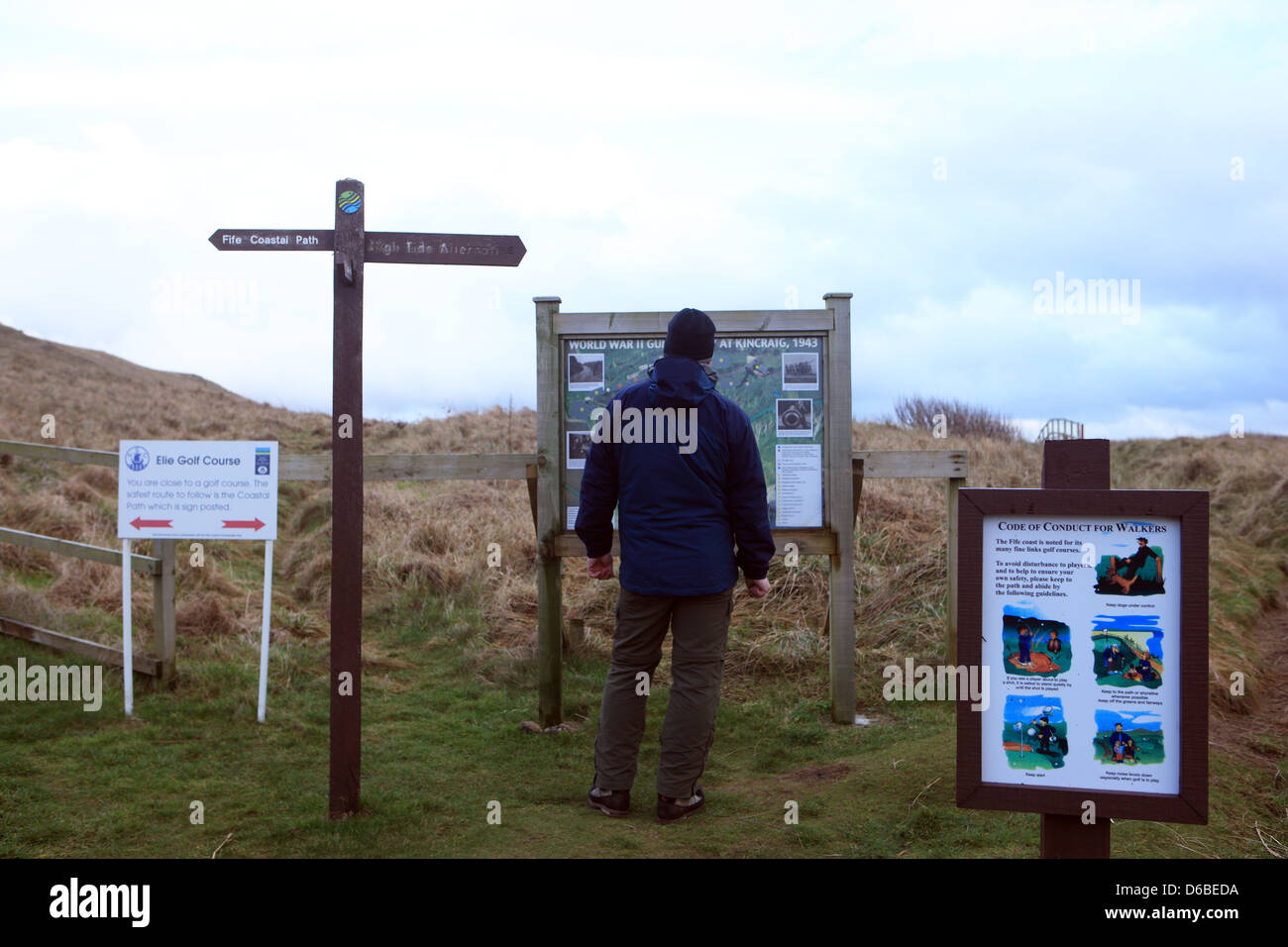 Mann liest eine Informationstafel über die Fife Coastal route Stockfoto
