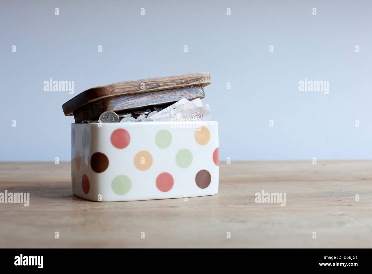 Glas voll Geld auf Schreibtisch Stockfoto