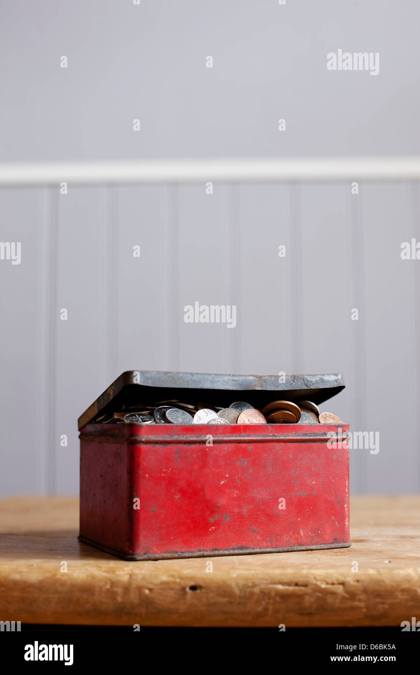 Antikes Zinn voller Geld auf Schreibtisch Stockfoto