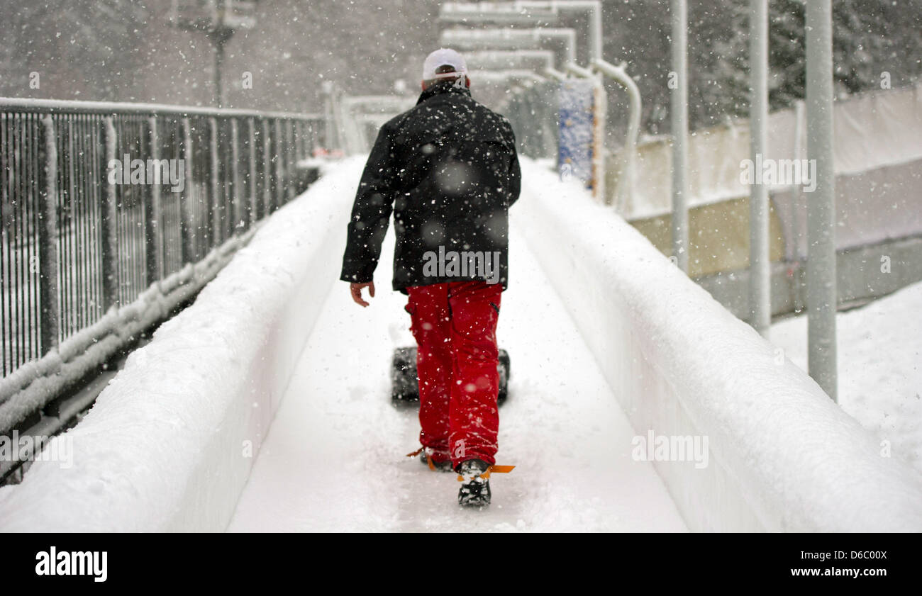 Ein Arbeiter entfernt Schnee Fron der Strecke die Männer vorher bei der Bob-Weltmeisterschaft in Altenberg, Deutschland, 7. Januar 2012. Foto: ARNO BURGI Stockfoto