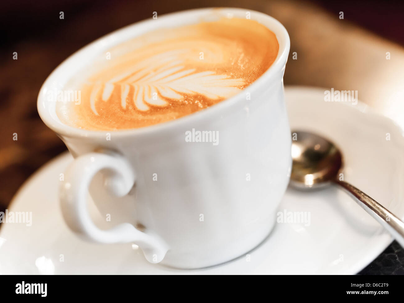 Cappuccino mit Gewürzen und künstlerische Schaum in eine weiße Tasse Kaffee Stockfoto