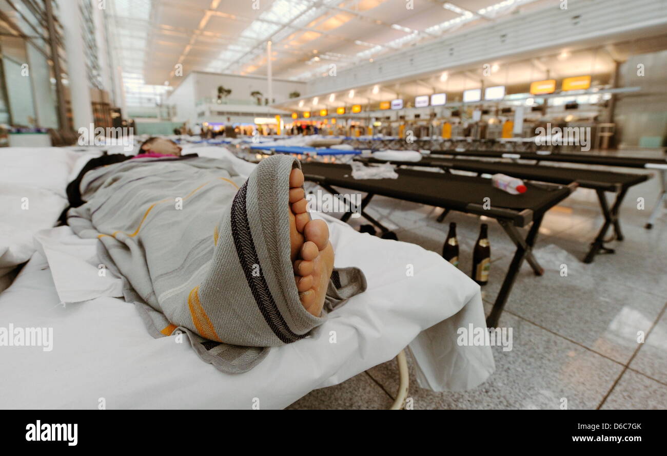 Ein Mann Schläft bin Mittwoch (05.09.2012) in München (Oberbayern) bin "Franz-Josef-Strauß"-Flughafen in der Schalterhalle Auf Einem Feldbett Studienabschnitte Hinter Ihm der Betrieb eine Höhle Schaltern Angelaufen ist. Die Gewerkschaft Ufo wegdrücken bin Quantenelektrodynamik Stewards Und Stewardessen der Lufthansa Implications, Ihre Arbeit Niederzulegen, if Flüge Wurden Gestrichen. Foto: Tobias Hase Dpa/lby Stockfoto