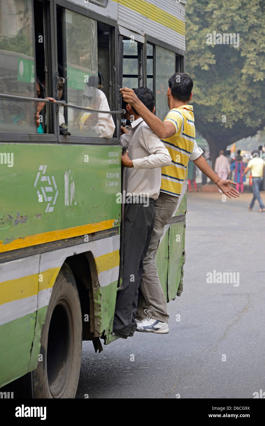 Busreisende klammerte sich an die Tür von einem alten Bus von Delhi in Indien Stockfoto Busreisende klammerte sich an die Tür von einem alten Bus von Delhi in Indien Stockfoto