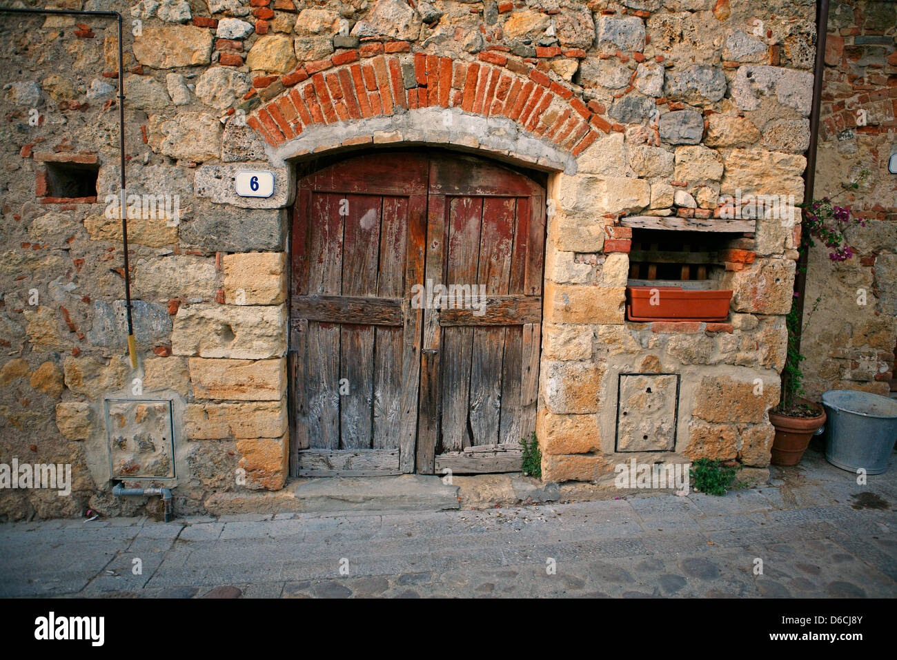 Alte hölzerne Tür in einem Steinhaus in Monteriggioni Toskana Italien Stockfoto