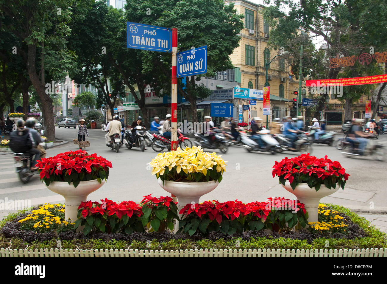 Horizontale Ansicht von Mopeds, das bevorzugte Transportmittel in Vietnam, fahren in alle Richtungen an einer belebten Kreuzung in Hanoi Stockfoto