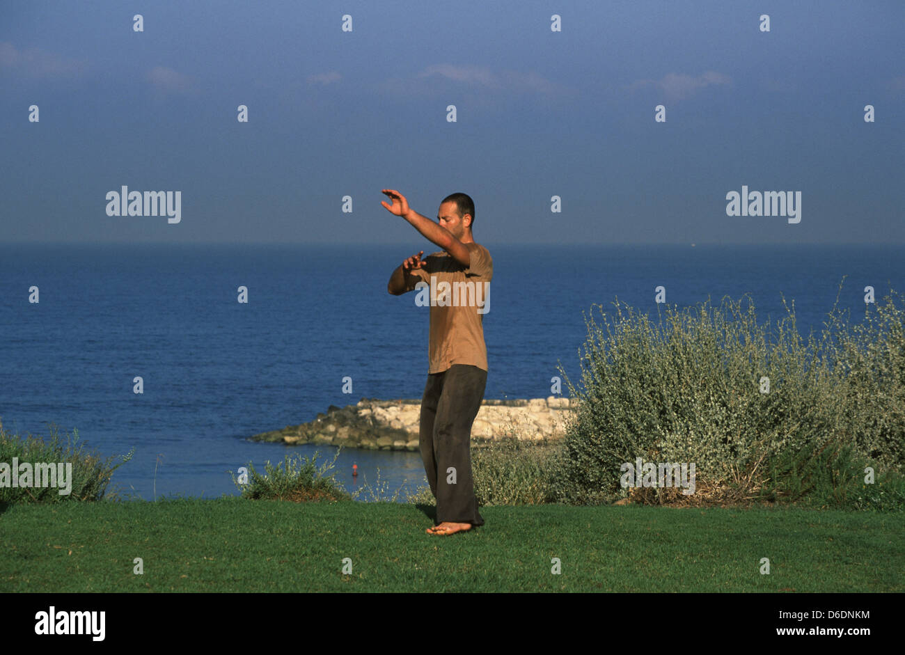 Ein Mann Üben von Tai Chi chinesische Kampfkunst An der mediterranen Küste von Tel Aviv in Israel. Stockfoto Ein Mann Üben von Tai Chi chinesische Kampfkunst An der mediterranen Küste von Tel Aviv in Israel. Stockfoto