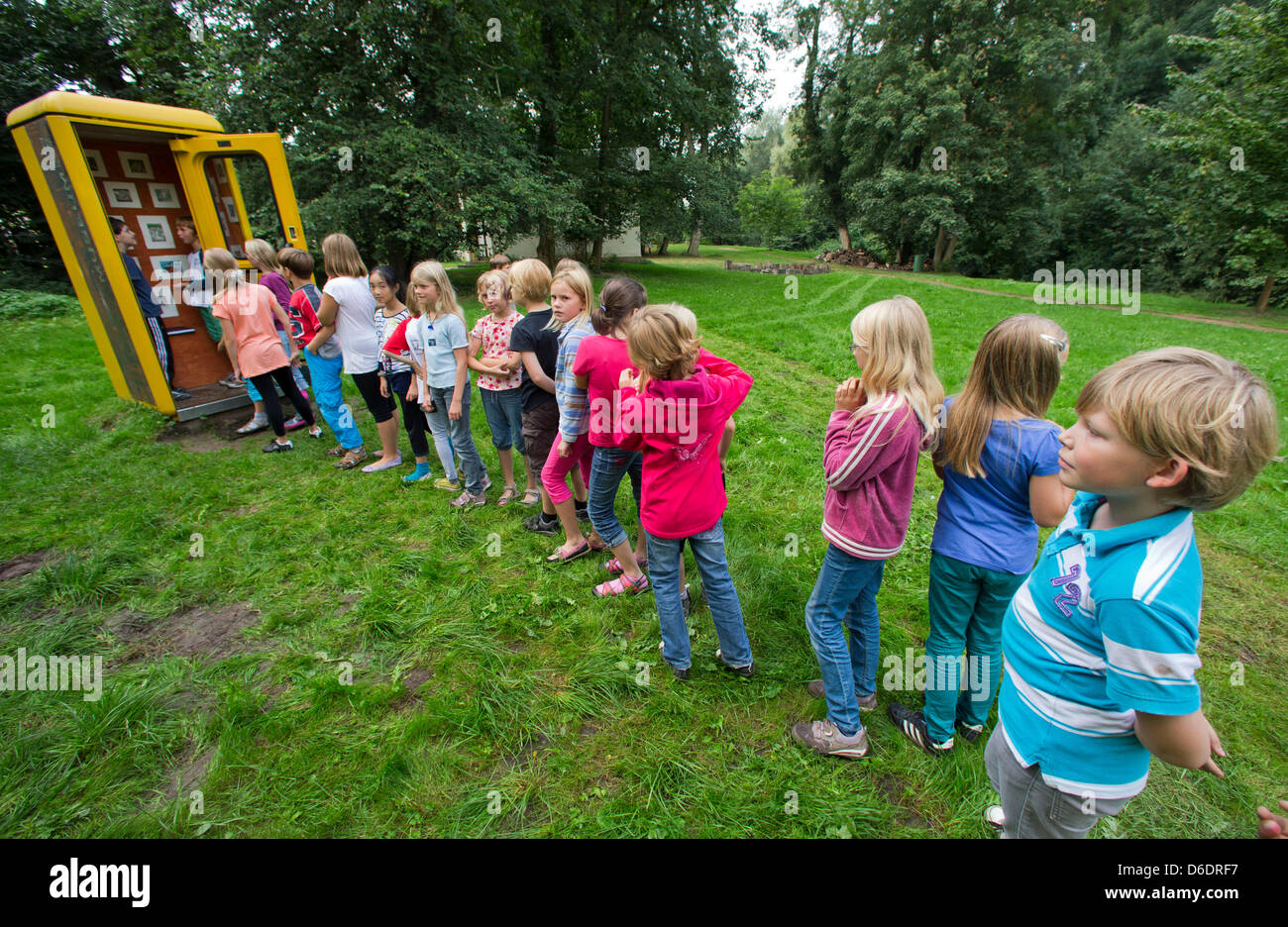 Vierte Klasse Schüler aus Rostock betrachten die meisten wahrscheinlich kleinste Museum Deutschlands in einem Park in Dreiluetzow, Deutschland, 11. September 2012. Die Mini-Museum zeigt wechselnde Ausstellungen des Künstlers in der Region derzeit Christa Schenk aus Neustadt-Glewe, mit einer Fläche von 90 von 90 Zentimetern. Foto: Jens Büttner Stockfoto