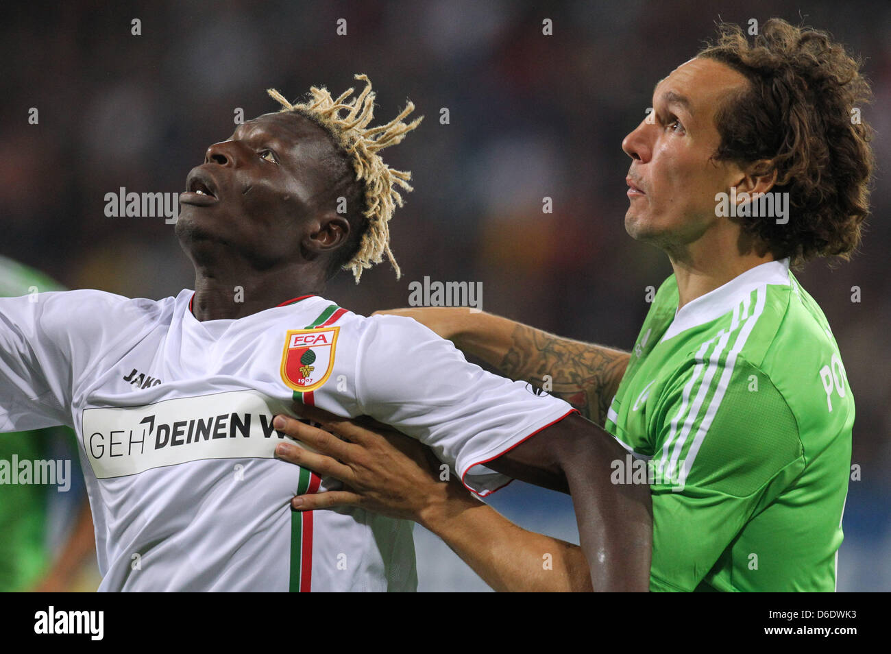 Augsburger Emanuel Pogatetz (R) wetteifert um den Ball mit Wolfsburger Aristide Bance (L) Duing die deutsche Bundesliga-match zwischen FC Augsburg und VfL Wolfsburg in der SGL Arena in Augsburg, Deutschland, 14. September 2012. Das Endergebnis war 0-0. Foto: Karl-Josef Hildenbrand Stockfoto