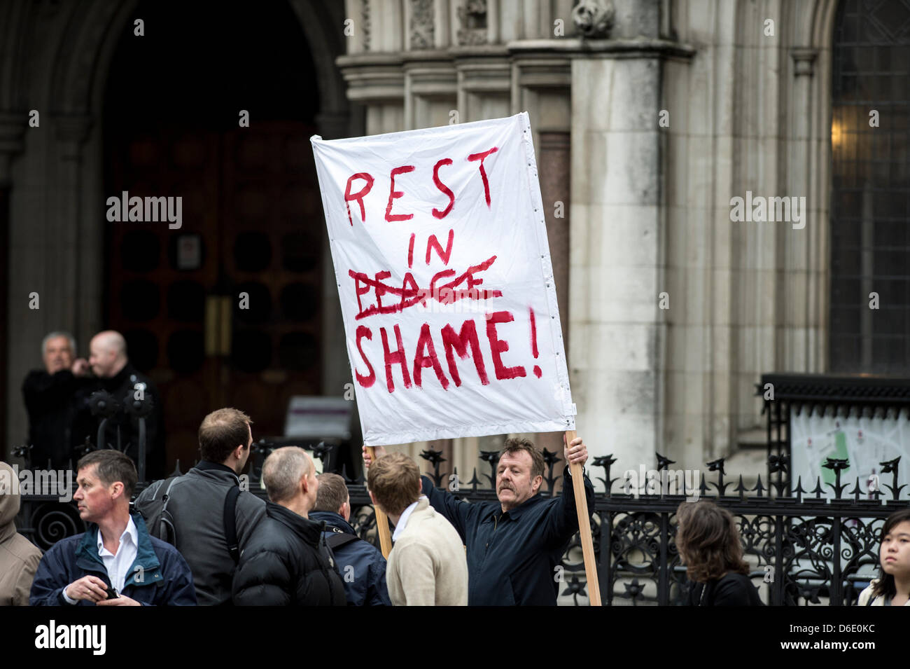 Der Strand. Ein Demonstrant hält einen Banner, das warten auf des Sarges von Lady Margaret Thatcher, während ihr Staatsbegräbnis übergeben. Stockfoto