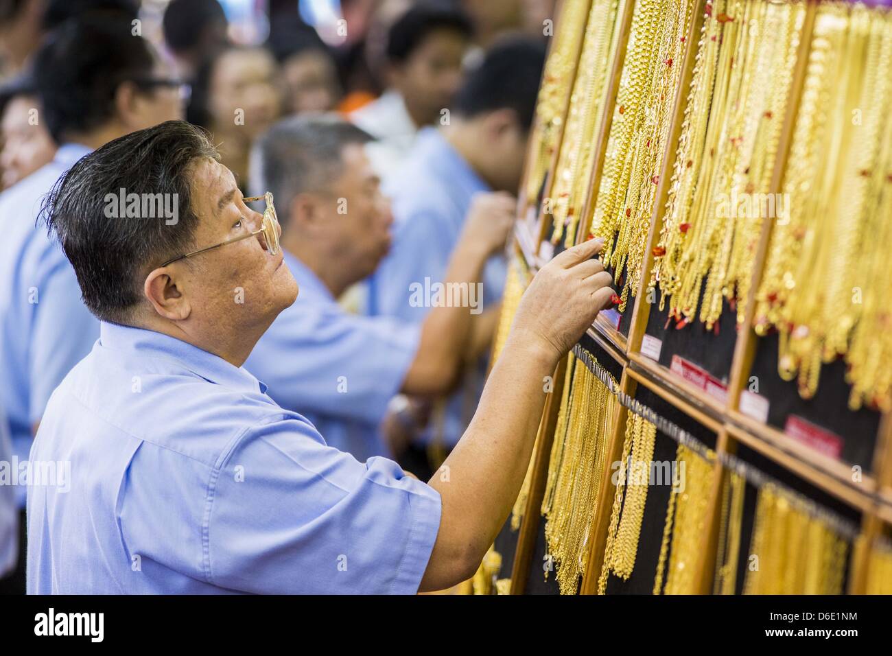 Bangkok, Thailand. 17. April 2013. Ein Verkäufer in einem gold Shop in  Bangkok ruft Goldketten für einen Kunden. Thais strömten, Goldgeschäfte in  Bangkoks Chinatown heute Morgen um Gold zu kaufen. Mittwoch war