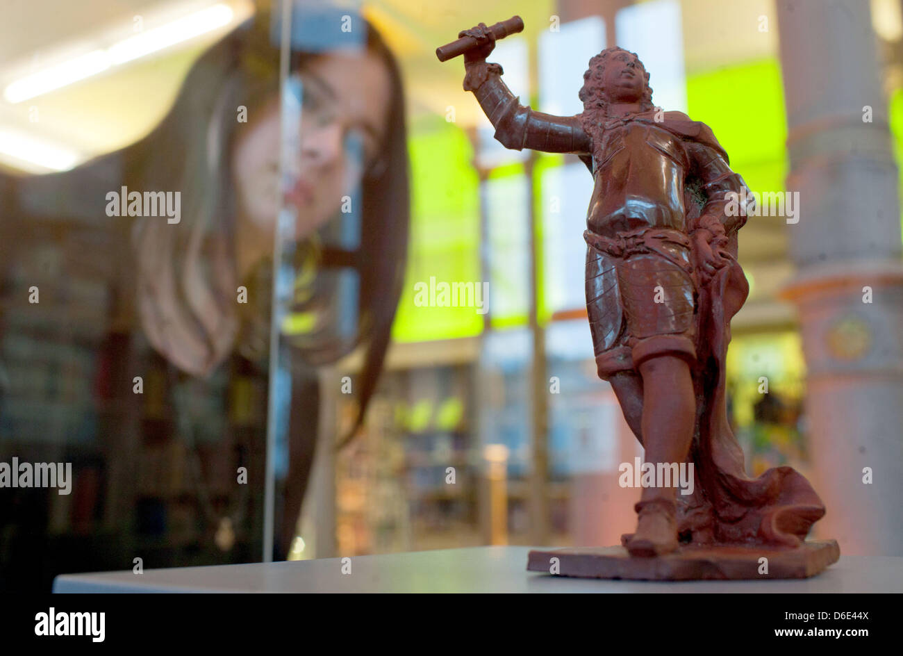 Ein Besucher schaut die wertvolle Meissen-Statuette des Generals aus Porzellan, die sitzen in einem Glaskasten im staatlichen Museum in Schwerin, Deutschland, 18. Januar 2012 gemacht. Das ungewöhnliche Werk der europäischen Kunstgeschichte, eine der frühesten Schöpfungen der Meissener Porzellan-Manufaktur, erhöht jetzt die Sammlung des Museums. Die Statuette wurde auf der ehemaligen Mecklenburg Landesmuseum du versteigert Stockfoto