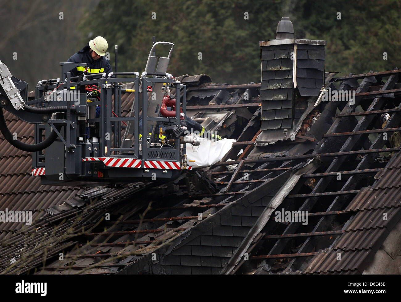 Feuerwehrleute abrufen die Leiche eines Kindes von verbrannten Dachbalken in Aachen, Deutschland, 18. Januar 2012. Bei einem Brand in einer Doppelhaushälfte starben drei Kinder. Foto: OLIVER BERG Stockfoto