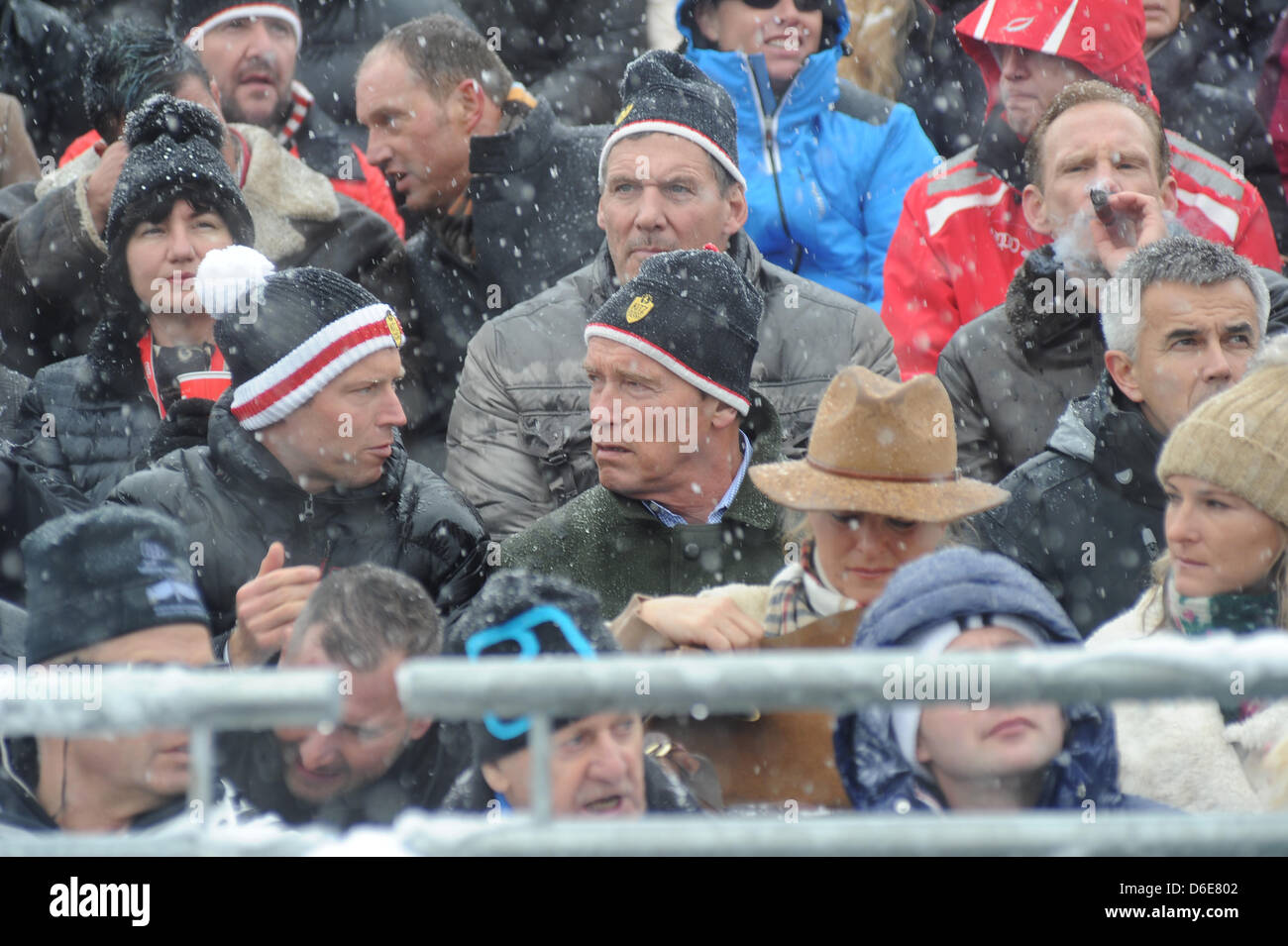 Österreichisch-US-Schauspieler und ehemalige US-Gouverneur von Kalifornien Arnold Schwarzenegger (C, vorne) und deutsche Schauspieler Ralf Moeller (C, oben) sehen die Männer bergab Hahnenkammrennen in Kitzbühel, Österreich, 21. Januar 2012. Das Elegendery-downhill-Rennen hat Alos ein Treffpunkt des Jetset. Foto: Felix Hoerhager Stockfoto