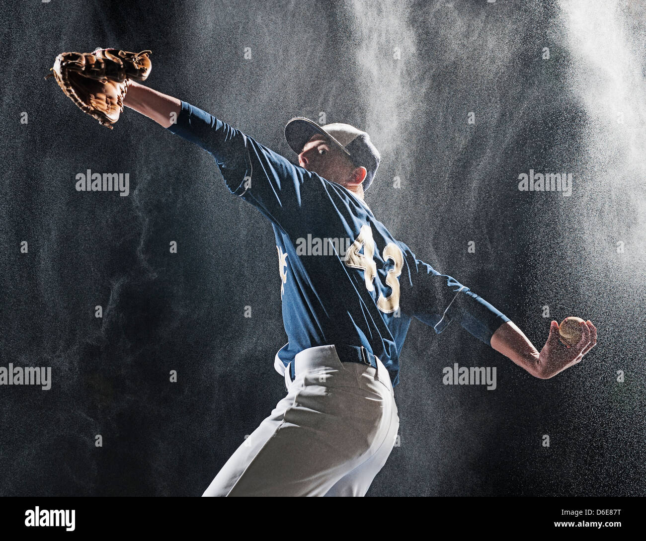 Kaukasische Baseballspieler pitching im Regen Stockfoto