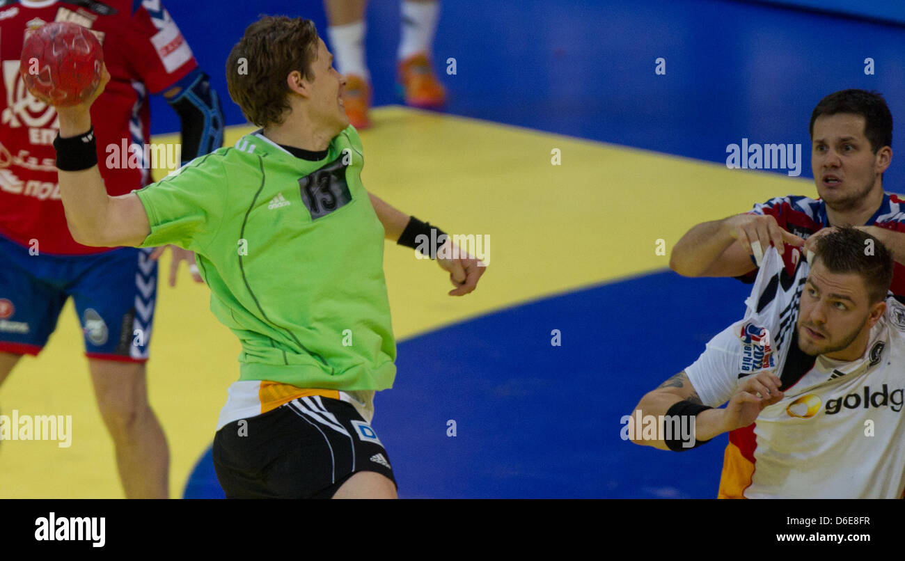 Deutschlands Sven-Sören Christophersen (L-R) punktet das 21-21 Ziel, während sein Teamkollege Christoph Theuerkauf mit Bojan Beljanski Serbien während der Handball-Europameisterschaft wetteifert match zwischen Serbien und Deutschland in Belgrad, Serbien, 21. Januar 2012. Foto: Jens Wolf Stockfoto