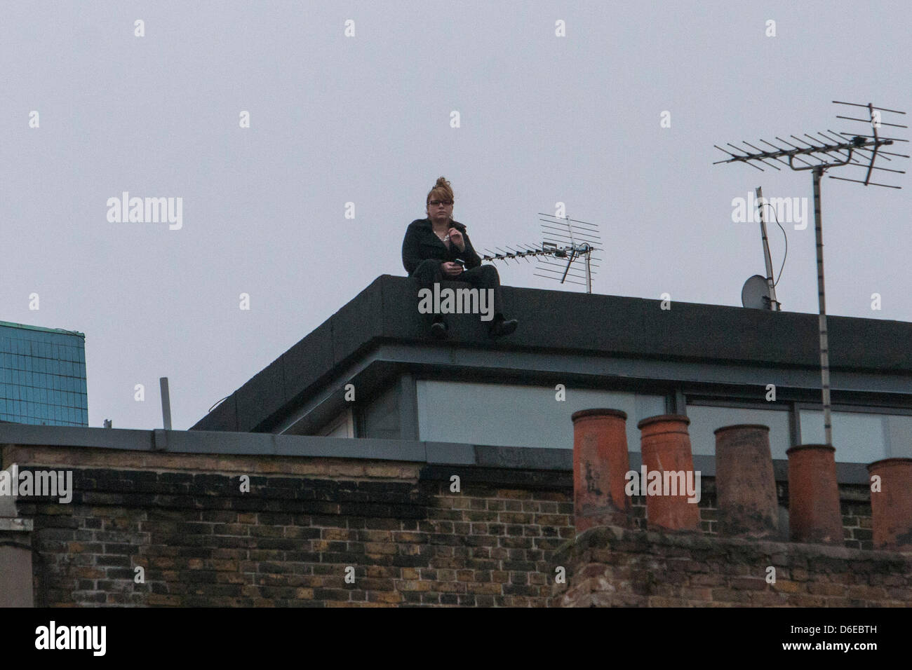 17. April 2013 London, UK. Einsame Frau sitzt auf dem Dach beobachten, Baroness Thatcher Trauerzug macht seinen Weg entlang der Fleet Street auf dem Weg zur St. Pauls Cathedral Stockfoto