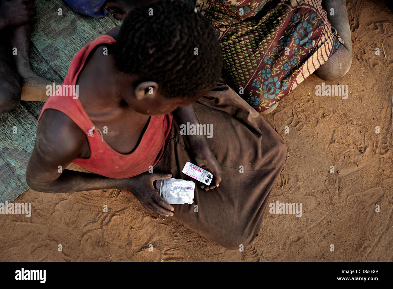 Alice Amito sitzt in einer Hütte mit Epilepsie Tabletten in der Hand im Bezirk Kitgum, Norduganda, 17. Januar 2012. Sie leidet unter Nodding Krankheit, die eine neue, unbekannte Krankheit, die im Sudan in den 1980er Jahren erschien. Kranken, Kinder zwischen fünf und 15 Jahre alt, sind körperlich und geistig verkümmert. Den meisten Fällen im Moment sind im Norden Ugandas und im Südsudan. S Stockfoto