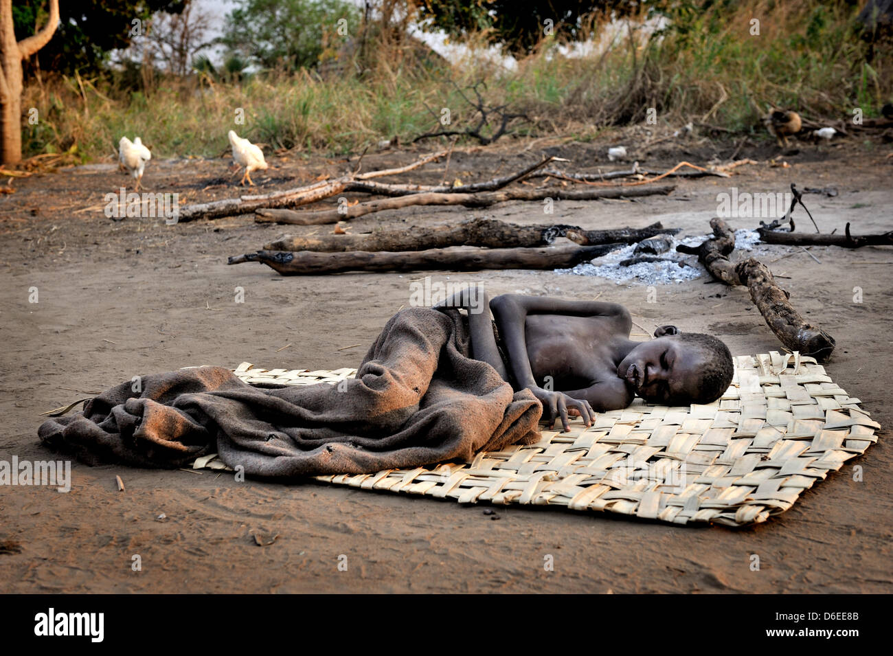 Patrick Anywar (14) liegt auf einer Matte vor einer Hütte im Bezirk Kitgum, Norduganda, 17. Januar 2012 abgemagert. Er leidet unter Nodding Krankheit, die eine neue, unbekannte Krankheit, die im Sudan in den 1980er Jahren erschien. Kranken, Kinder zwischen fünf und 15 Jahre alt, sind körperlich und geistig verkümmert. Den meisten Fällen im Moment sind im Norden Ugandas und im Südsudan. Stockfoto