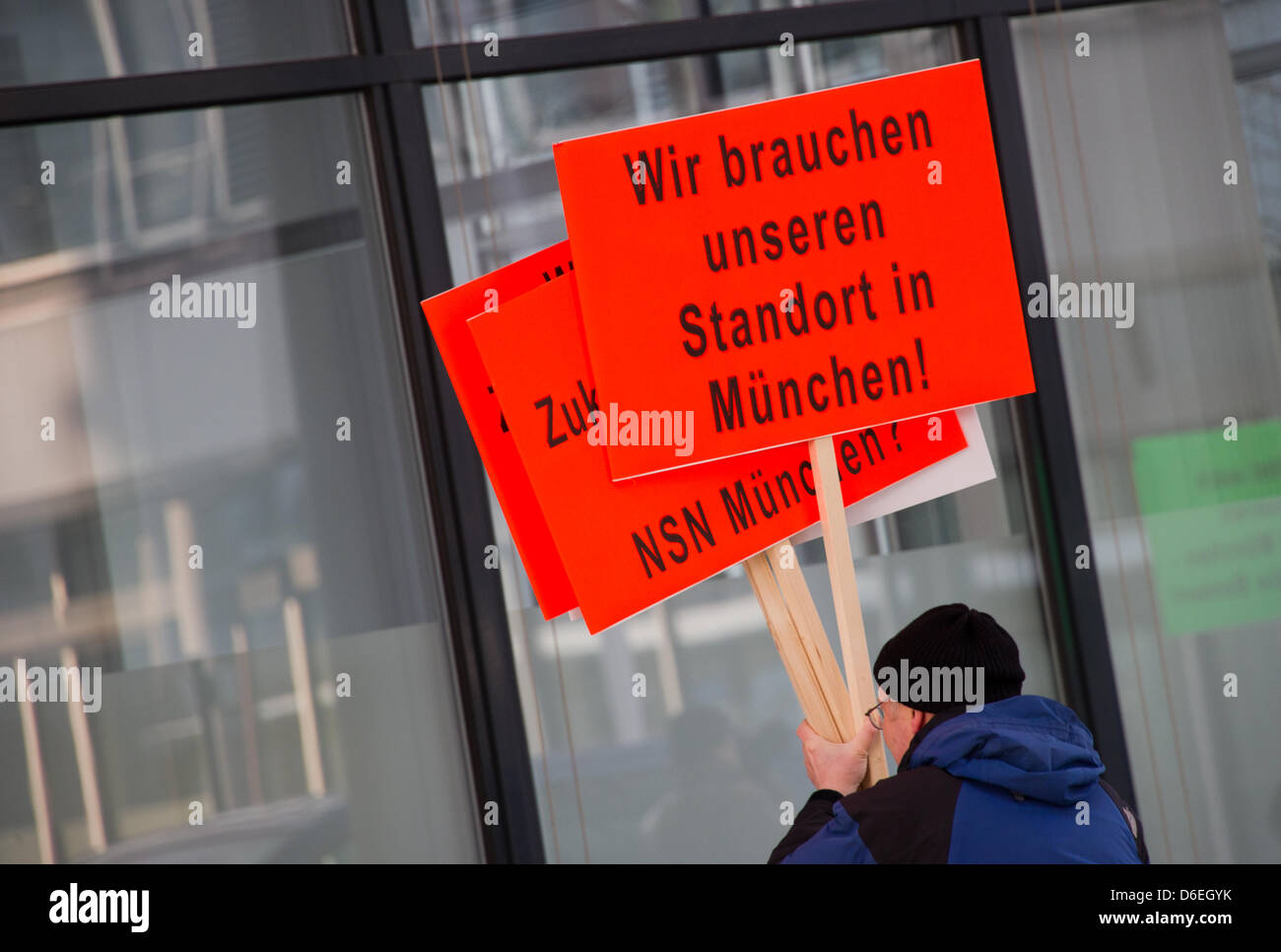 Ein Mann Hält Bei Einer Protestaktion von Mitarbeitern des Netzwerkausrüsters Nokia Siemens Networks (NSN) bin Mittwoch (01.02.2012) Plakate Vor der FA der edierte NSN-Niederlassung in München (Oberbayern). Sterben Aktion Richtet Sich Gegen Die Geplante Schließung des Standorts München Und Den Abbau von Bundesweit Rund 2900 Stellen. Zu der Protestkundgebung Hut sterben IG Metall auf Stockfoto