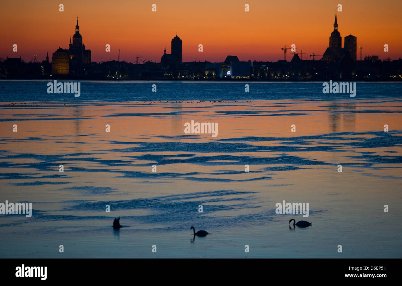 Das Stadtbild der Hansestadt Stralsund ist gegen einen bunten Himmel während des Sonnenuntergangs aus Rügen, Deutschland, 31. Januar 2012 abgebildet. Die Stadt ist ein UNESCO-Weltkulturerbe für die Menschheit. Die Stadt das Stadtrecht stammt aus 1234 und es wurde eine Hansestadt vom Ende des 13. Jahrhunderts. Foto: Stefan Sauer Stockfoto