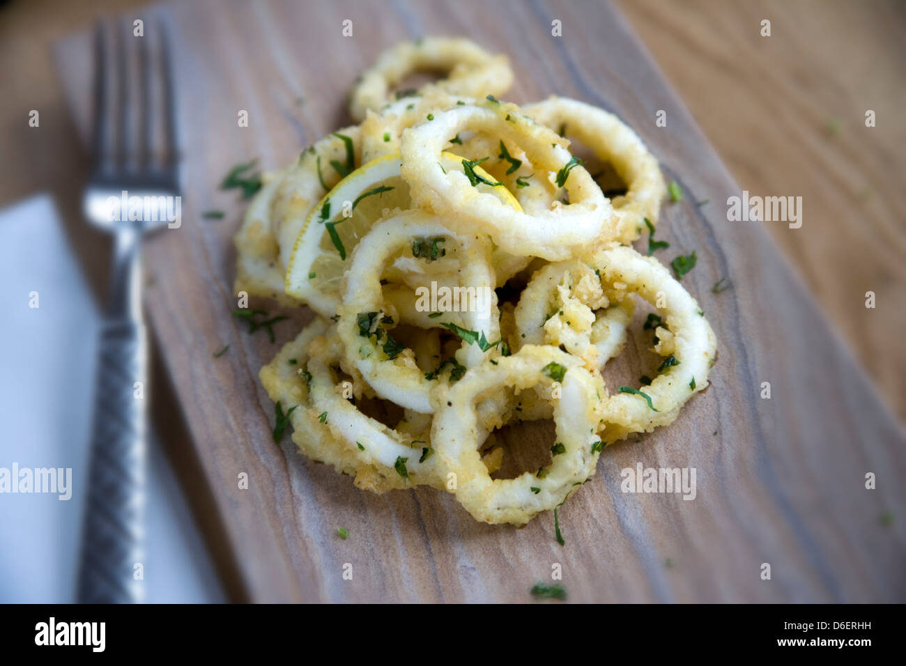 Tintenfisch Ringe in gewürzten Mehl mit Petersilie und Zitrone Stockfoto