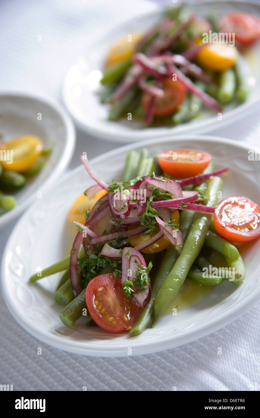 Salat mit Tomaten, grüne Bohnen, rote Zwiebel und Öl. Stockfoto