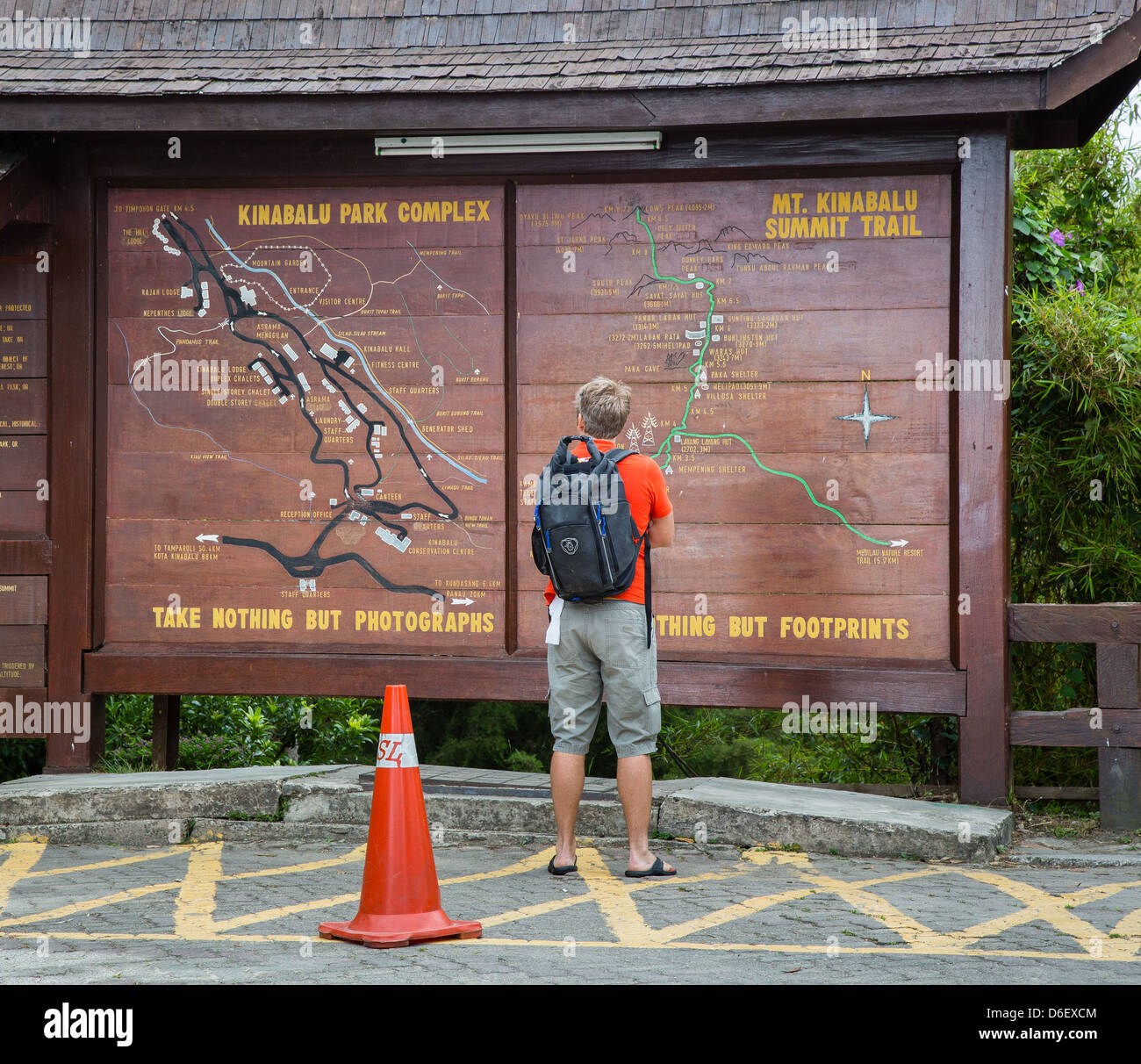 Ein Mann steht die Infotafel zum Mount Kinabalu Trail Park Hauptquartier in Sabah Borneo lesen Stockfoto