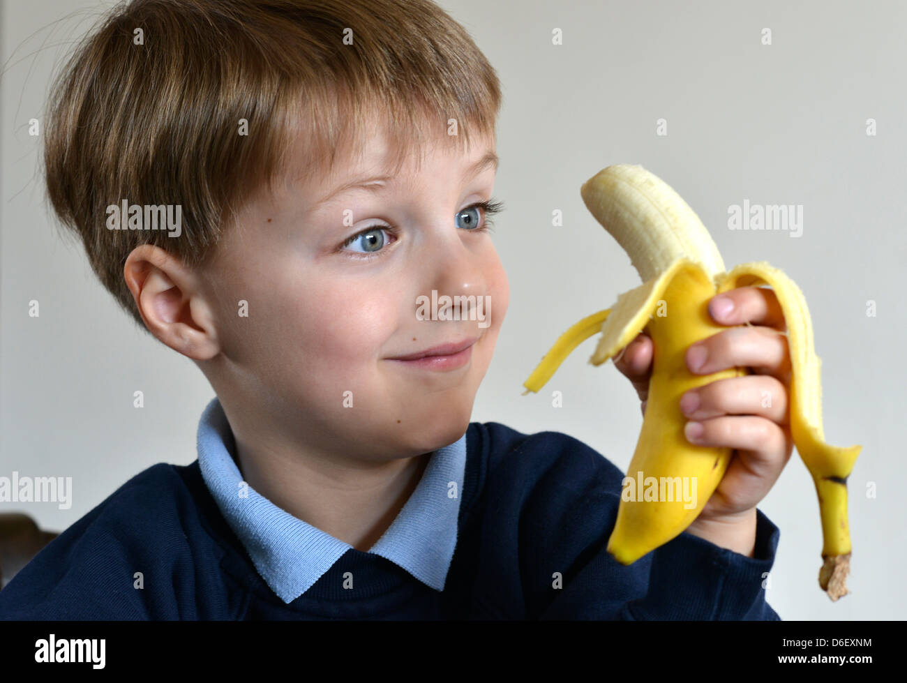 Ein Lächeln auf den Lippen Schuljunge im Alter von fünf eine Banane essen. Stockfoto