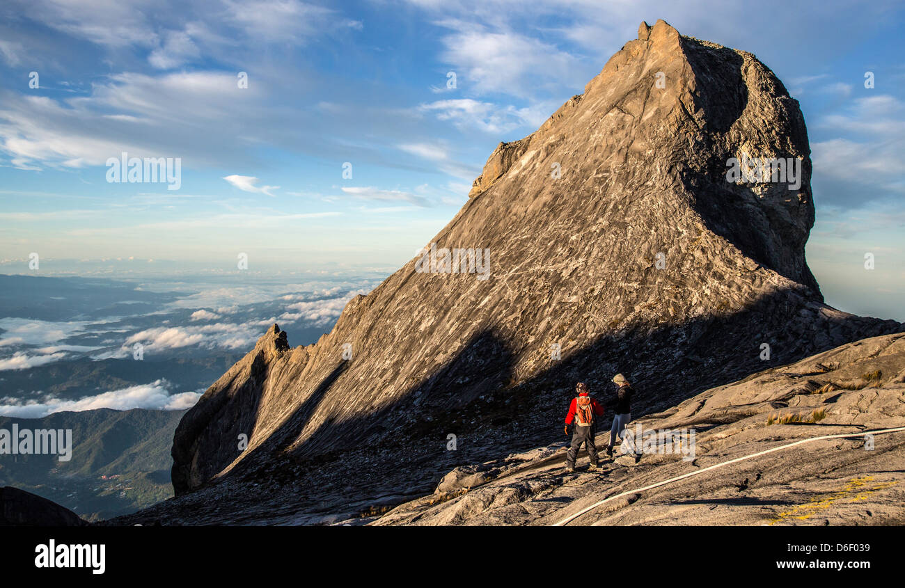 Zwei Kletterer absteigend die vergletscherten Granit hängen des Mount Kinabalu auf Borneo gehen vorbei an Str. Johns Peak unterhalb des Gipfels Stockfoto