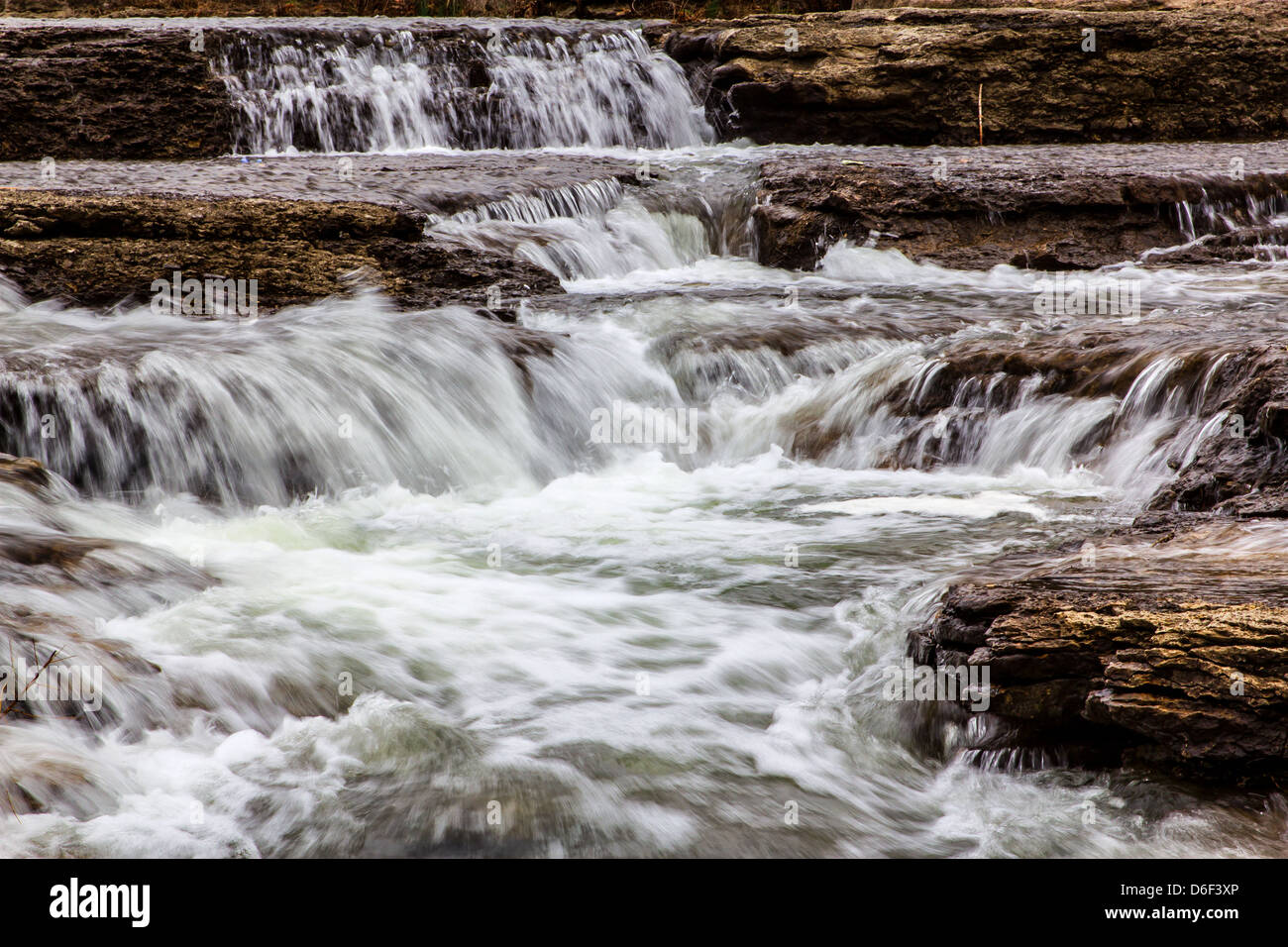 Bewegtes Wasser über einen Wasserfall und Hochwasserentlastung Stream. Stockfoto