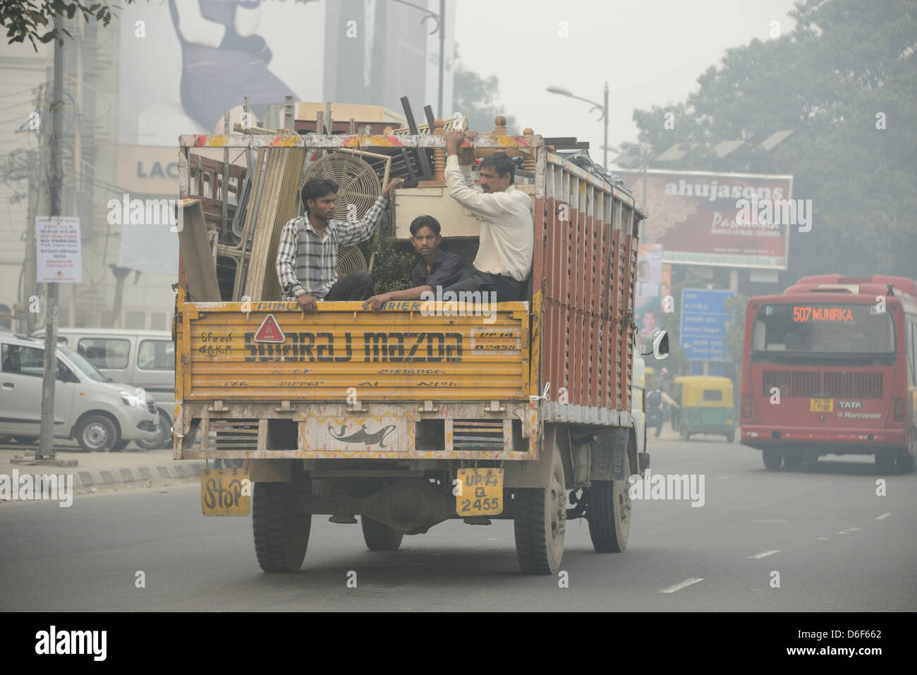Indische Arbeiter auf der Rückseite eines Lastwagens in Delhi, Indien Stockfoto