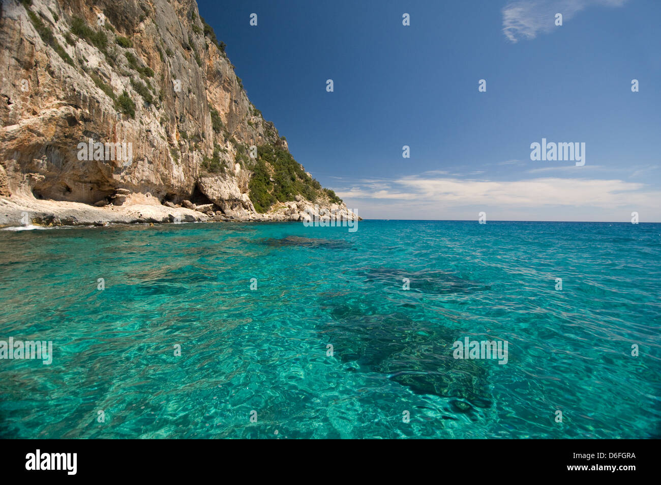 Hohe Klippen mit klaren und transparenten Wasser des Meeres an der Küste in der Nähe von Cala Mariolu Strand, Baunei, Orosei Golf, Sardinien, Italien Stockfoto