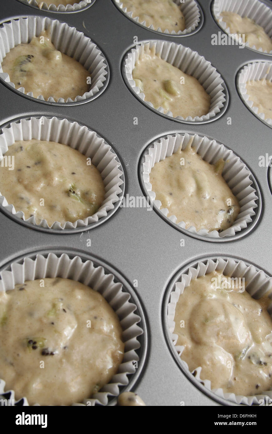 Kiwi-Teig in Muffin-Fällen im Fach fertig gekocht werden Stockfoto