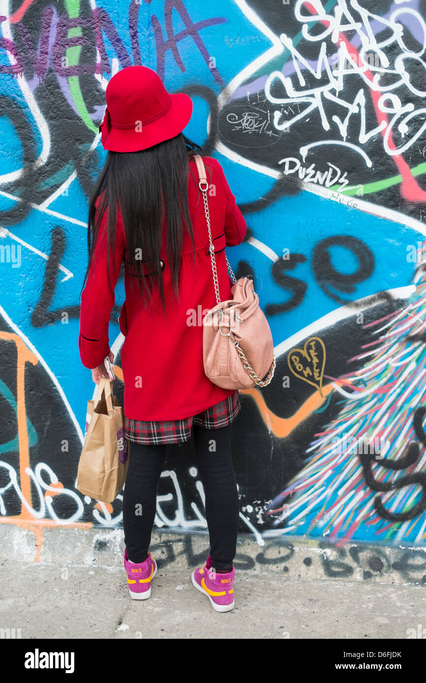 Asiatische Touristen schreiben an die Berliner Mauer in der Eastside Gallery Stockfoto