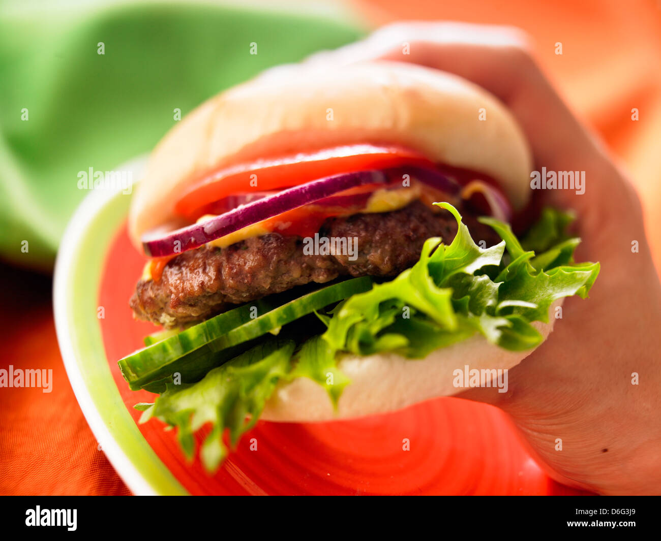 Burger, Salat, lustvoll. Hand Stockfoto