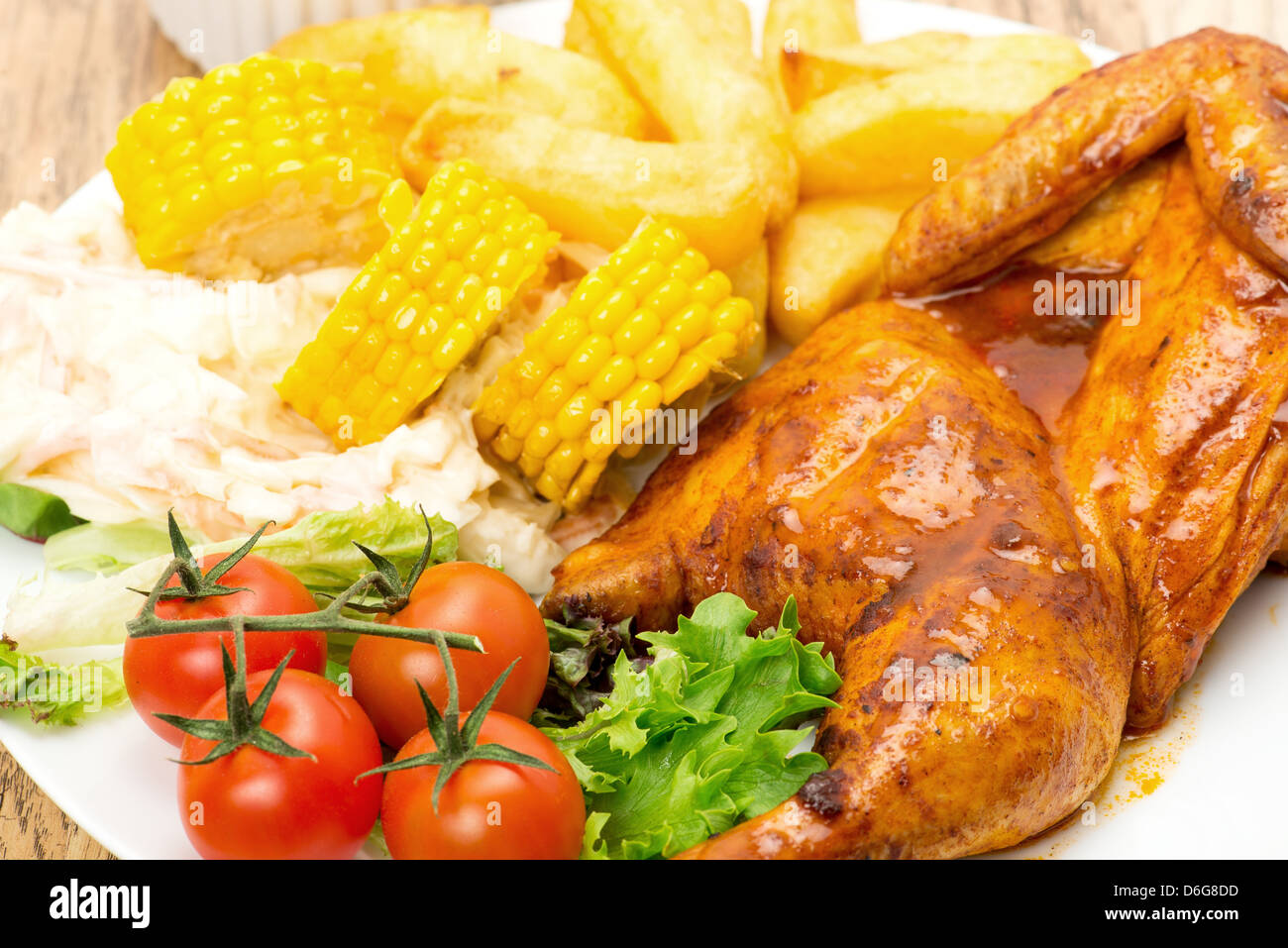 Ein Hähnchen Piri-Piri mit Pommes frites, Mais und Salat - typisch portugiesischen Abendessen Stockfoto