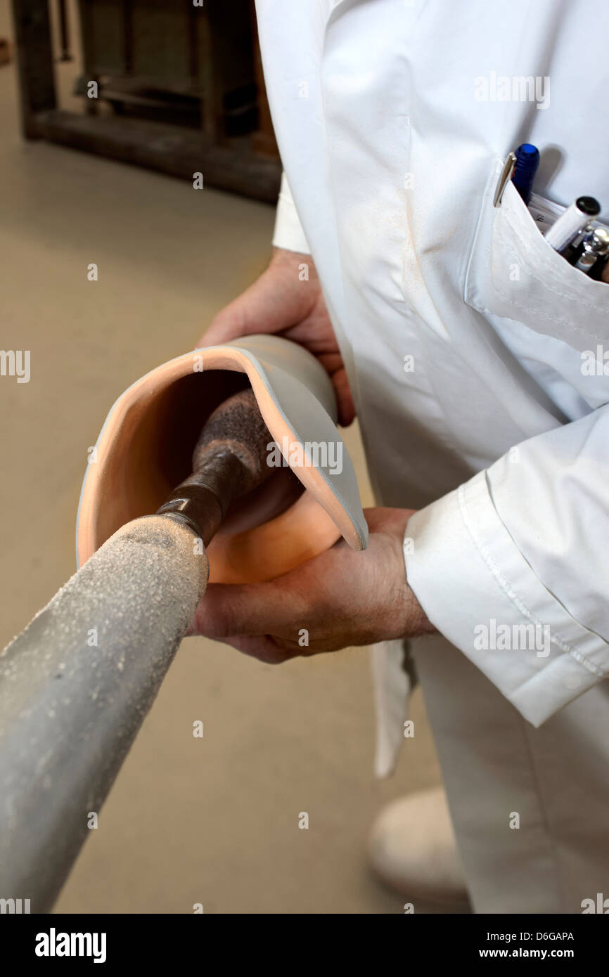 Ein Arbeiter in einem Tunnel Schleifmaschine. Die innere Form der Prothesen funktionieren. Stockfoto