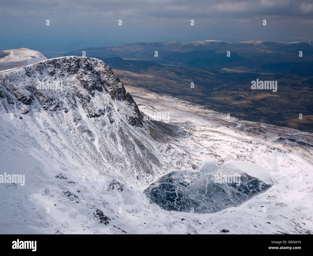 Blick vom Penygadair über einen gefrorenen Llyn y Gader, Cyfrwy - Winter auf Cadair Idris, Snowdonia. Stockfoto