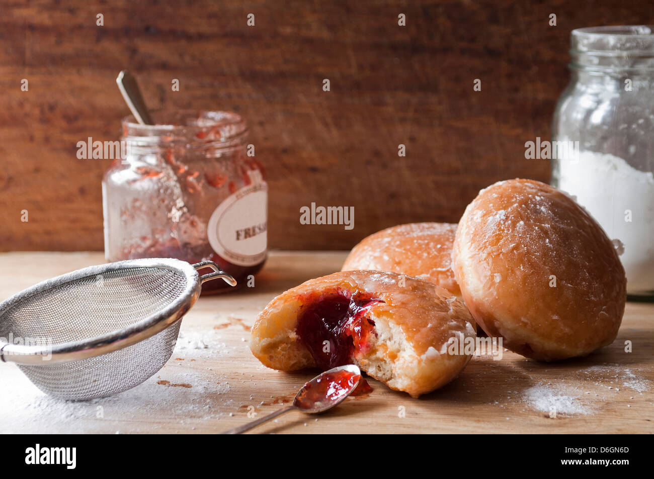 Krapfen, Marmelade und Zucker auf Tisch Stockfoto