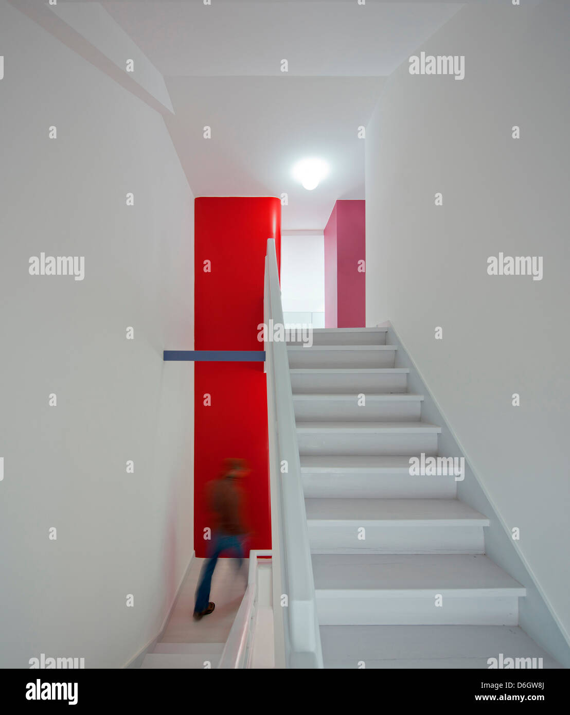 Casa Em Almada, Almada, Portugal. Architekt: Pedro Gadanho, 2012. Innen Treppe mit roten Schränken darüber hinaus. Stockfoto