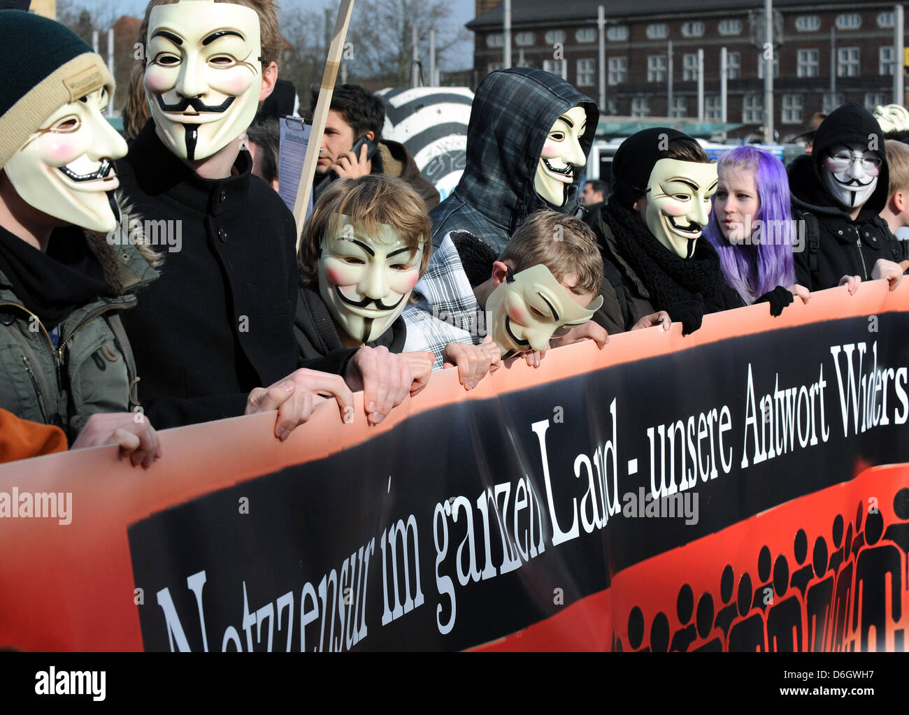 Demonstranten tragen Masken beteiligen sich an einer Demonstration gegen das Anti-Counterfeiting Trade Agreement in Bremen, Deutschland, 25. Februar 2012. Rund 2000 Menschen nahmen an der Demonstration gegen das internationale Abkommen zum Schutz geistigen Eigentums online. Foto: INGO WAGNER Stockfoto