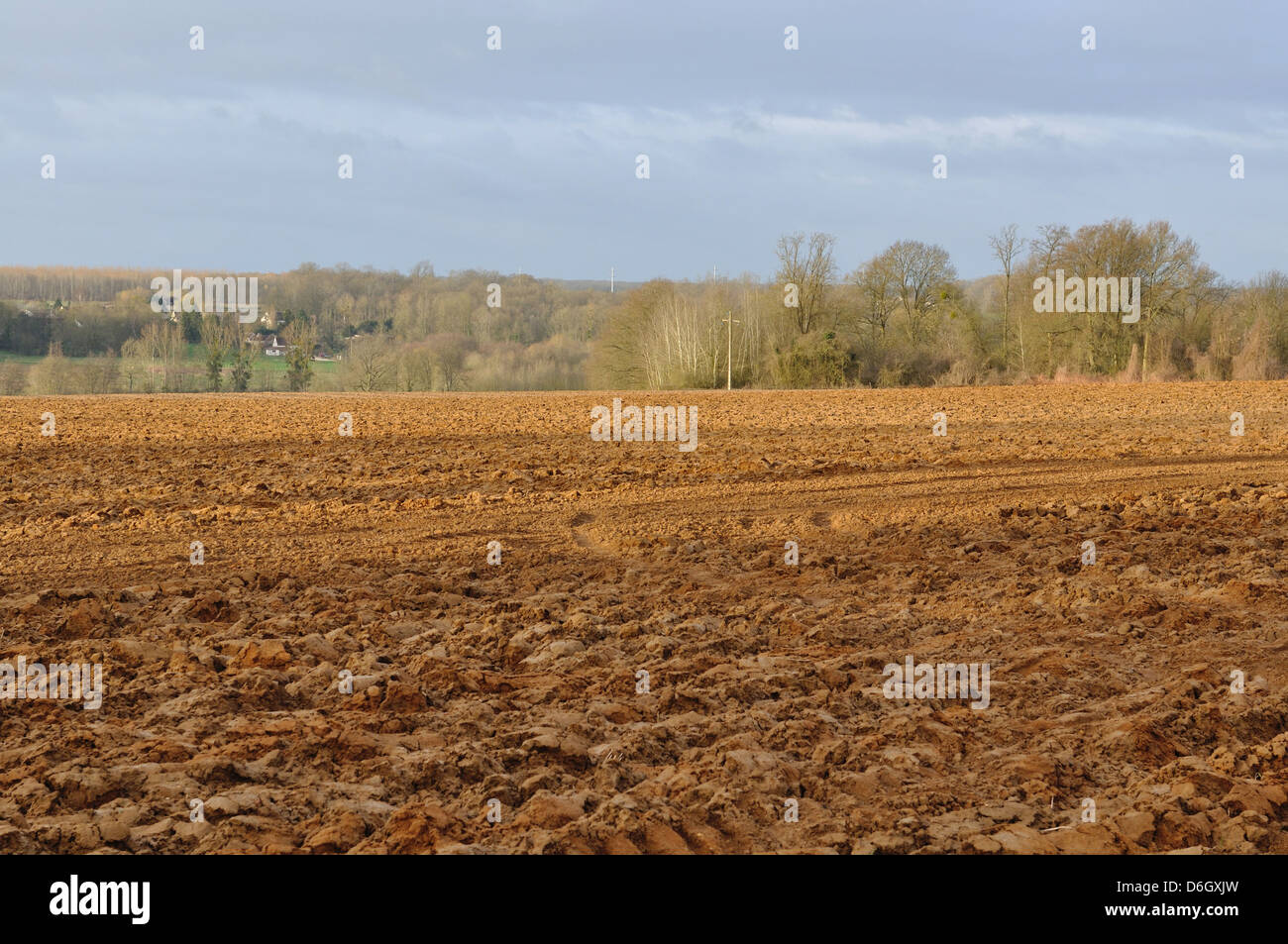 Land gepflügtes Feld bei bewölktem Himmel Stockfoto