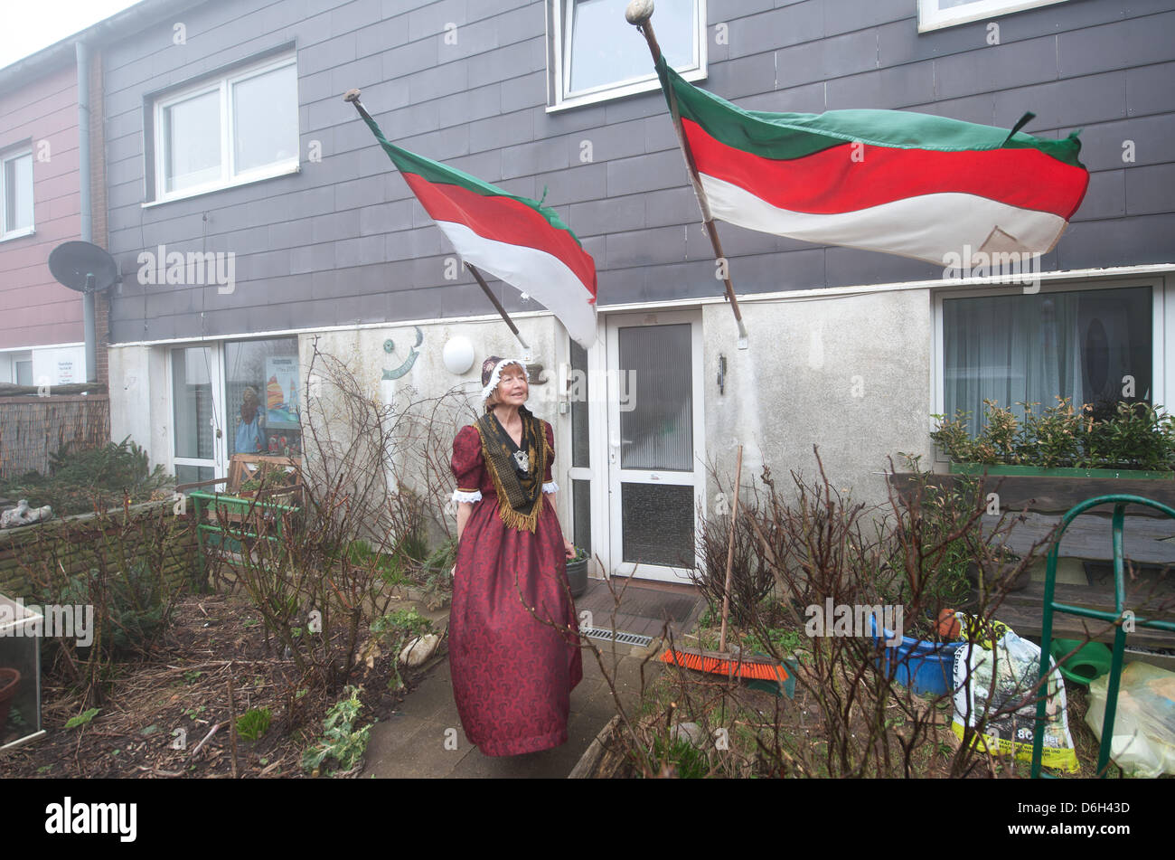 Bürger von Helgoland Eschi Waltemath steht vor ihr dekoriert festlich Haus in einem historischen Kleid in Helgoland, Deutschland, 1. März 2012. Eine Zeremonie fand statt, um den 60. Jahrestag der Wiederherstellung der Insel nach Deutschland zu feiern. Am 1. März 1952 restauriert die Briten die Insel an die deutschen Behörden. Foto: CHRISTIAN CHARISIUS Stockfoto