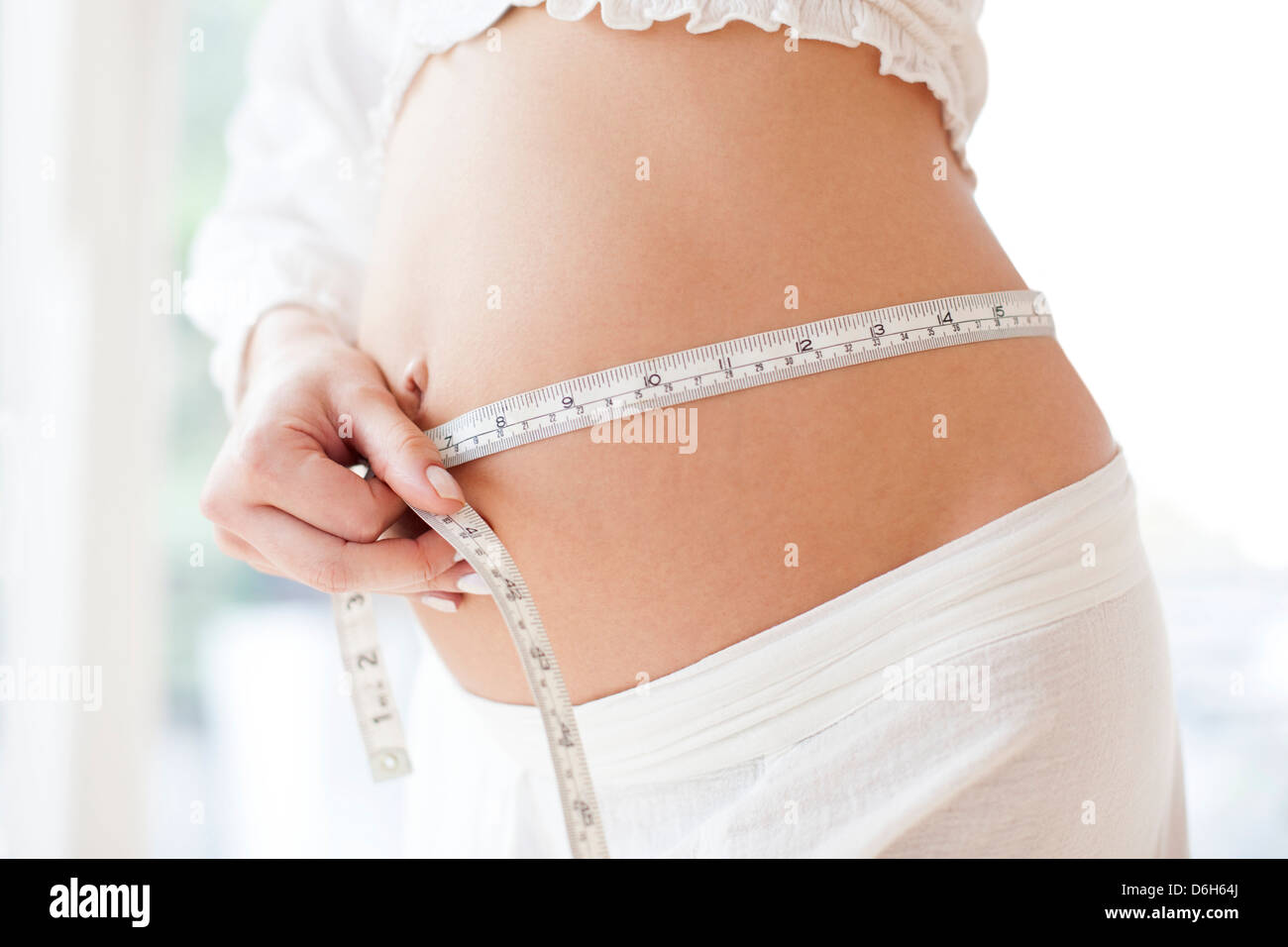 Schwangere Frau Messung ihres Bauches Stockfoto