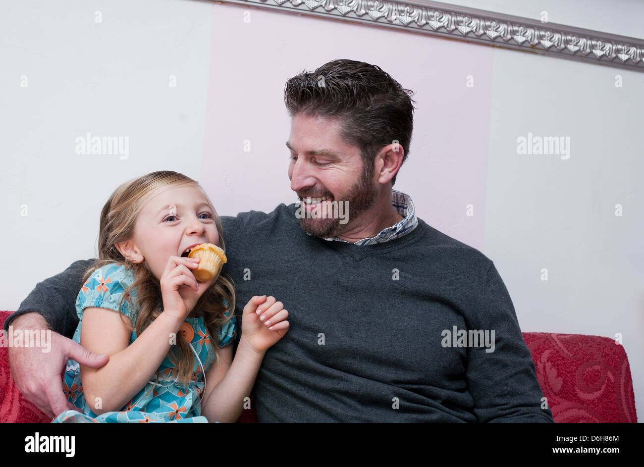 Vater und Tochter Essen Muffins Stockfoto