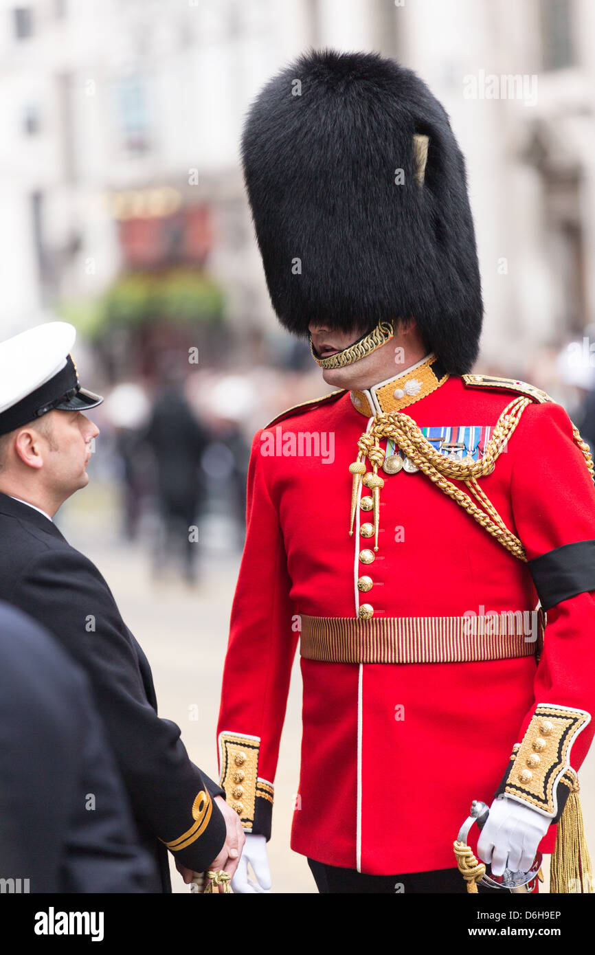 Ein Mitglied der Königinnenwache haben ein kurzes Gespräch mit einem anderen Soldat während der Prozession für Thatchers Beerdigung. Stockfoto