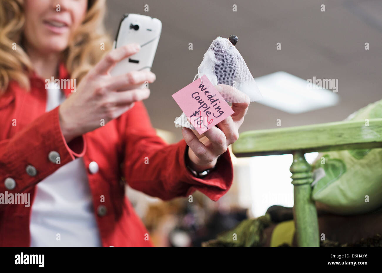 Frau unter Bild im Secondhand-Laden Stockfoto