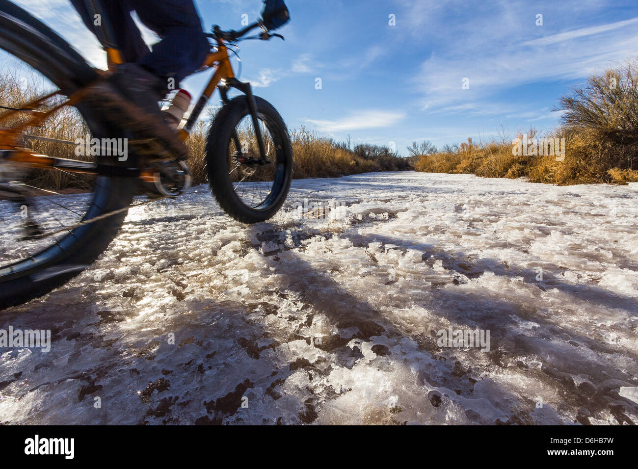 Mountainbiker auf Schnee im ländlichen Bereich Stockfoto