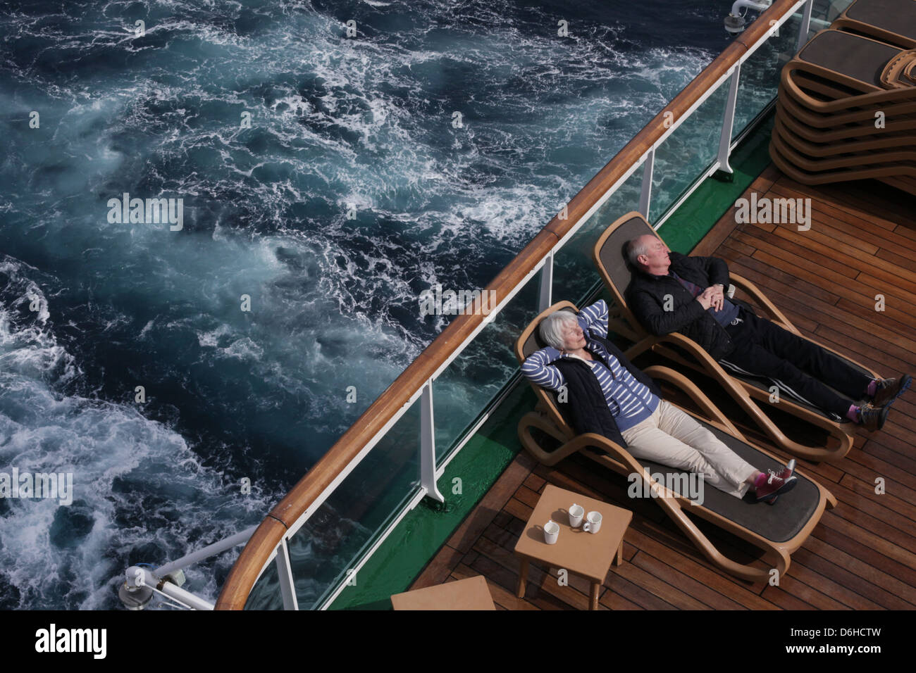 Ein älteres Ehepaar entspannen in der Sonne auf dem hinteren Deck des Kreuzfahrtschiffes P & O m.v. Azura Schiff auf einen Urlaub am Mittelmeer Stockfoto